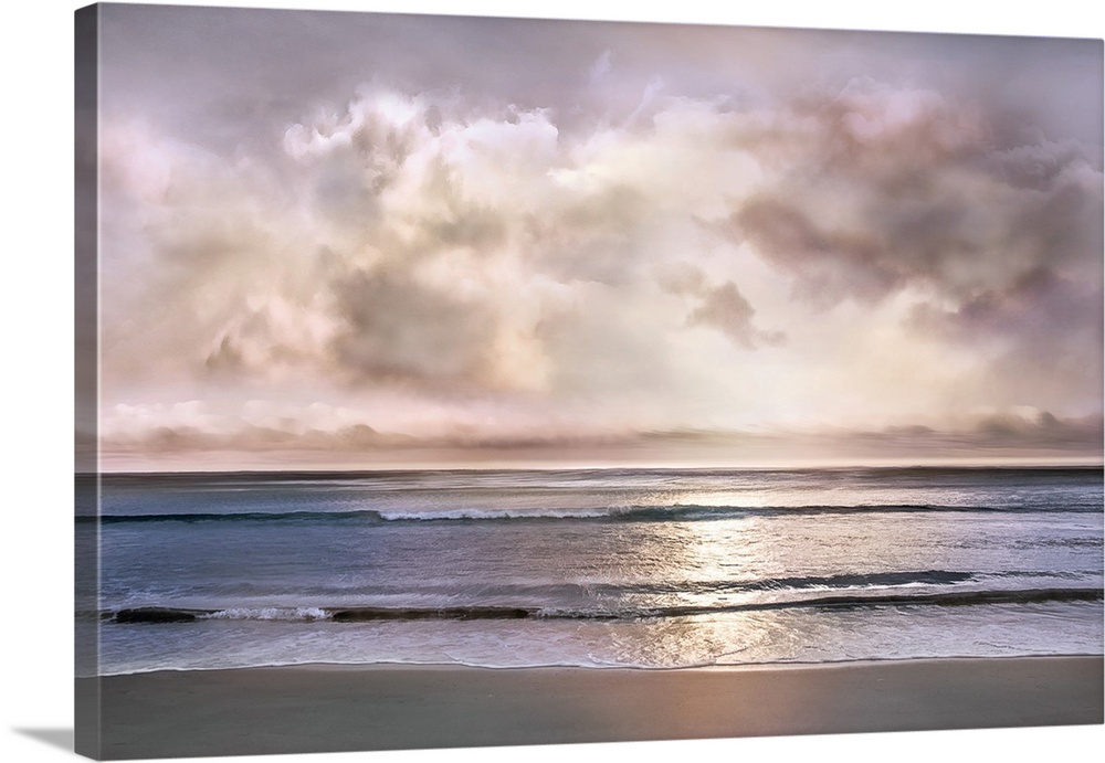 Landscape photograph where the ocean and shore meet with a light pink and purple sunset pushing through the cloudy sky.