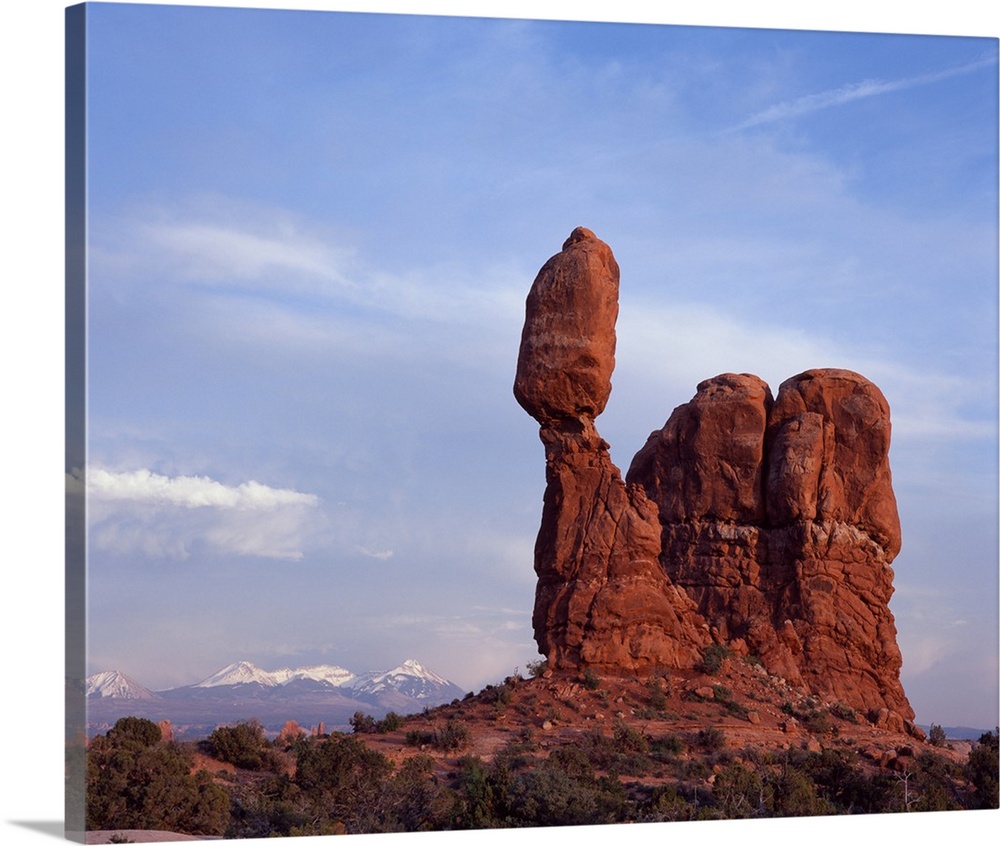 Landscape photograph of Balancing Rock in Utah with snow capped mountains in the distance.