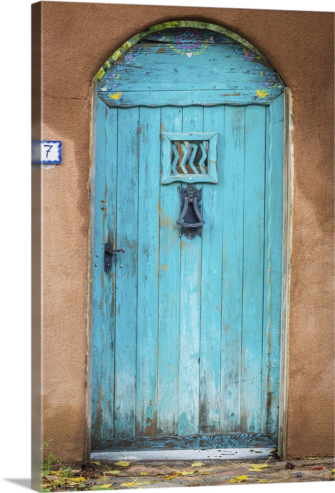 Photograph of a bright blue door in an adobe wall.