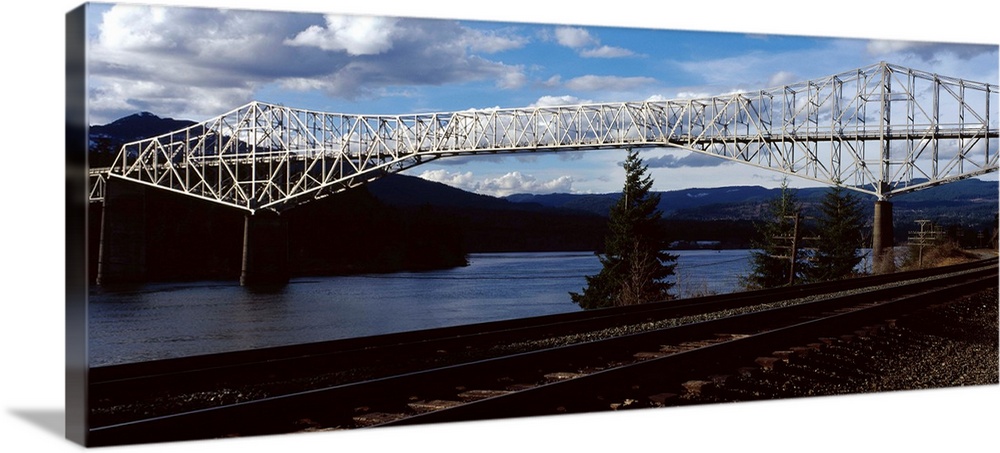 Photograph of the Bridge of the Gods over the Columbia River in Washington, with railroad tracks on the side.