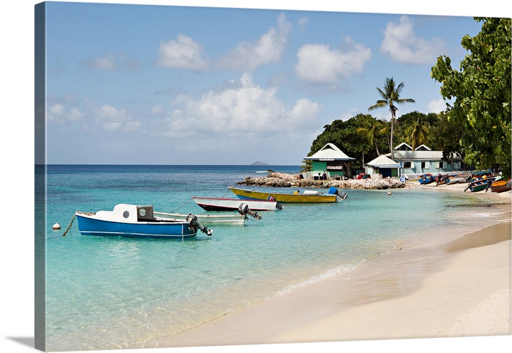 Landscape photograph of blue Caribbean waters with anchored boats by the beach.