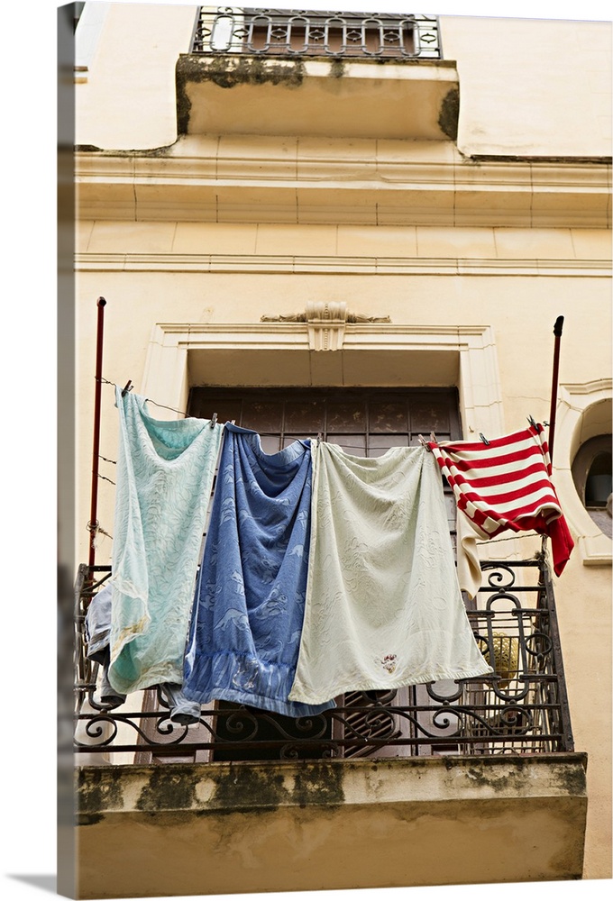 Photograph of laundry drying on a line outside of a window in Cuba.