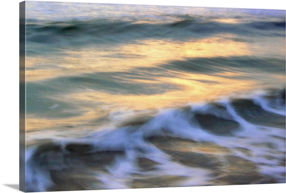 This picture is taken softly out of focus of small waves that are beginning to curl near the coast.