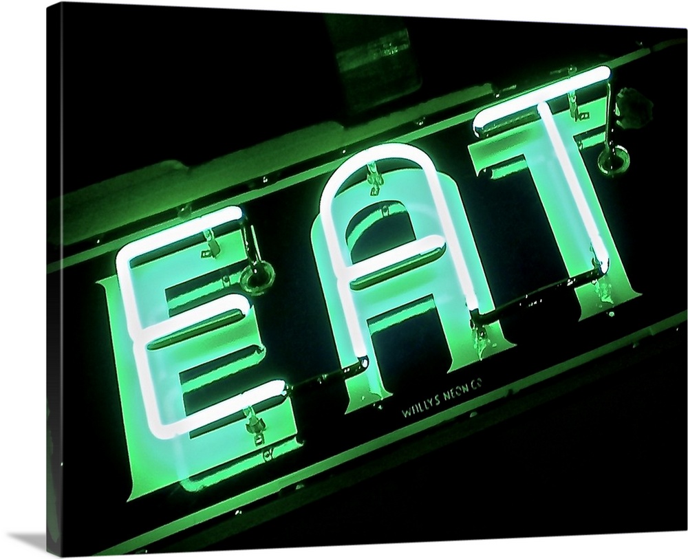 Photograph of a green neon sign lit up at night that reads "EAT"