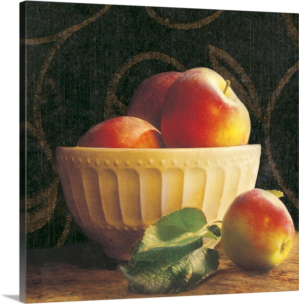 Giant photograph shows a group of three apples sticking out the top of an ornamental bowl on a table, while a lone apple a...