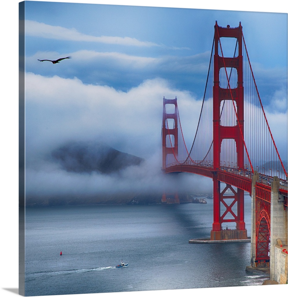 Square photograph of the Golden Gate Bridge in San Francisco with a boat in the bay and a bird in the sky on a foggy day.