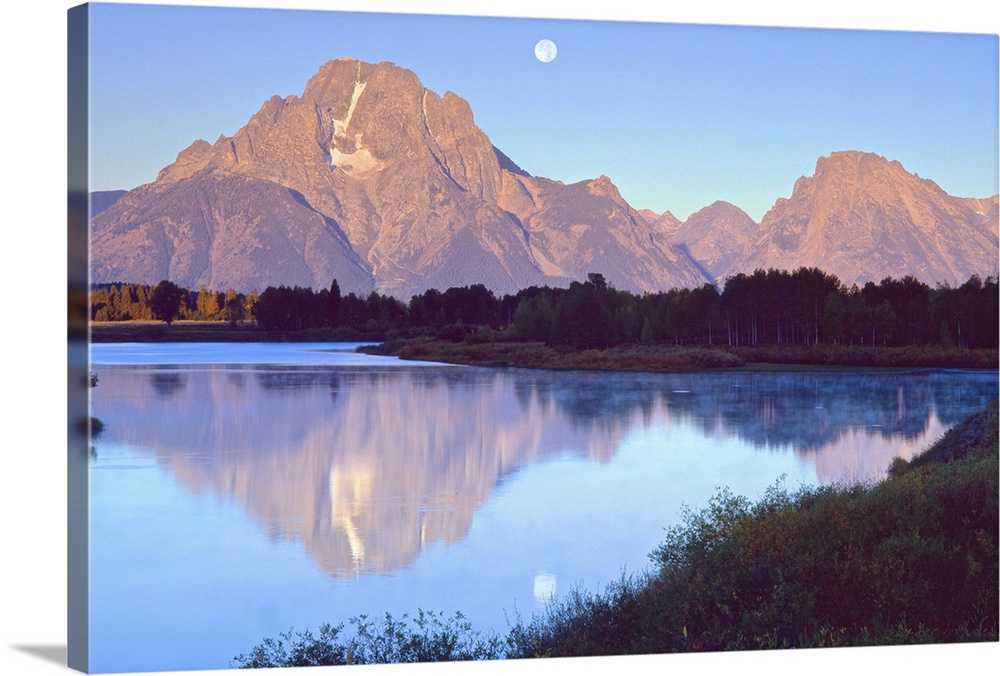 The moon over the Grand Tetons in Wyoming, reflected in the lake below.