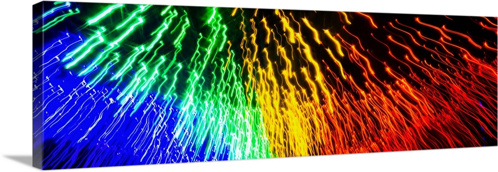 Panoramic abstract photograph of rainbow light trails.