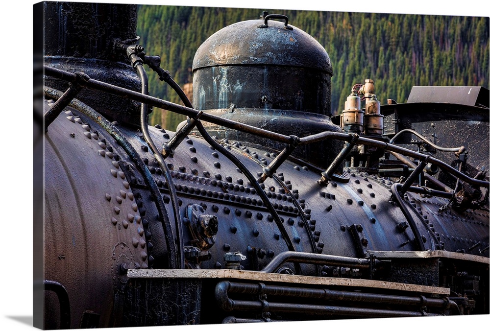 Photograph of an old train engine in a rail yard.
