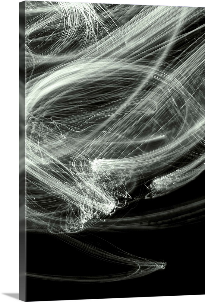 Long exposure abstract photograph of white light trails giving a smokey look with a black background.