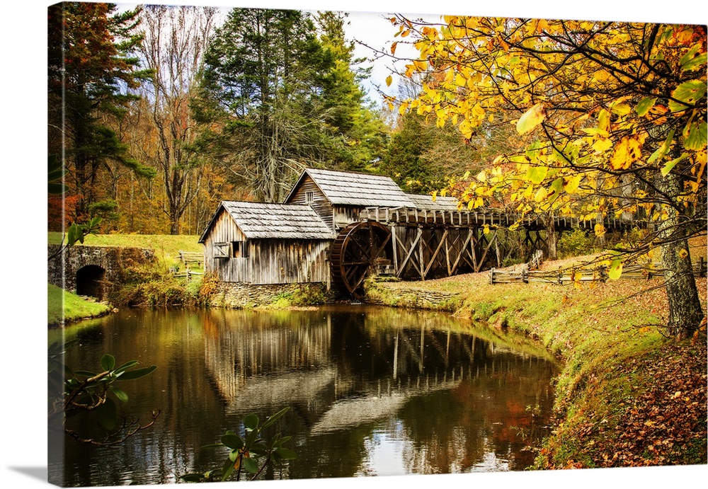 An old wooden watermill in a forest in the fall.