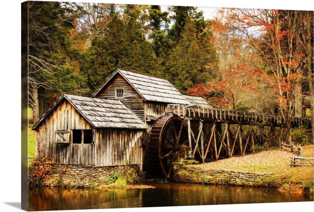 An old wooden watermill in a forest in autumn.