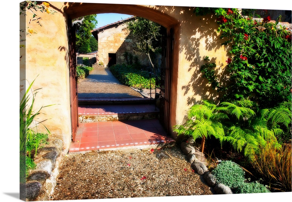 Landscape photograph of a pathway through an arch lined with greenery in Carmel, California.