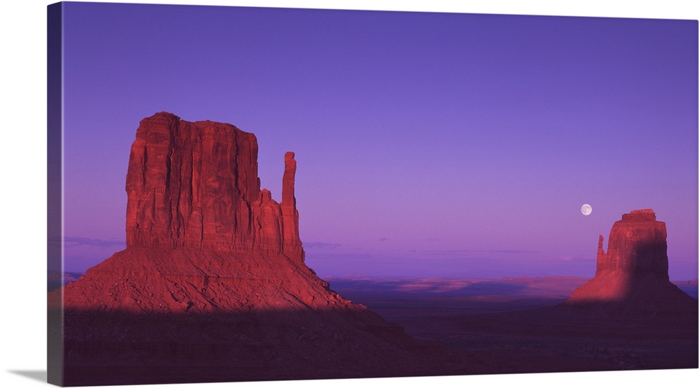 The "Mittens" rock formations in Monument Valley, Arizona, at dusk.