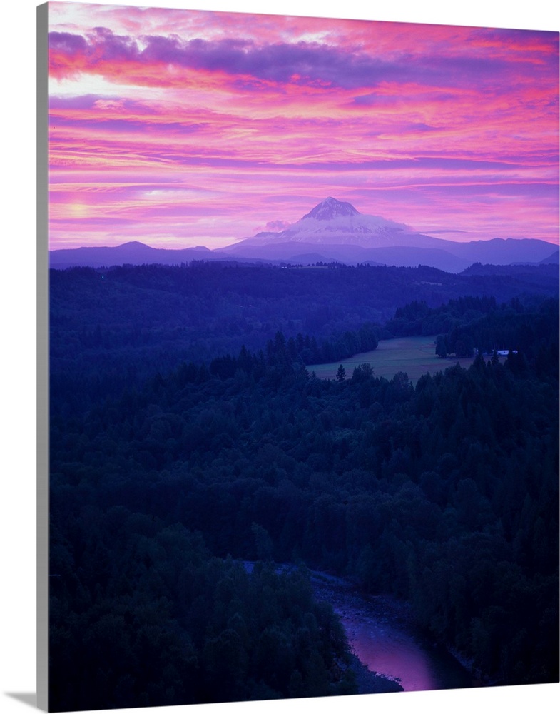 Purple clouds at sunset over Mount Hood covered in fog in the distance.