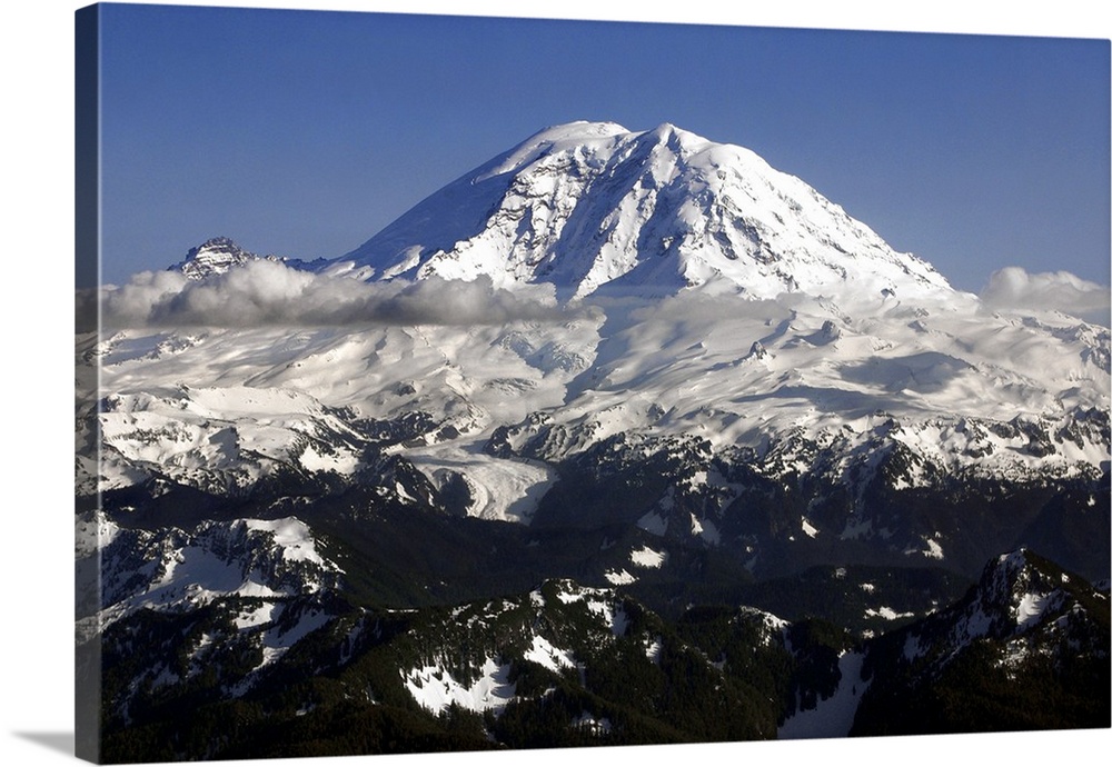 Landscape photograph of a snowy Mount Rainier in Washington with low hanging clouds.