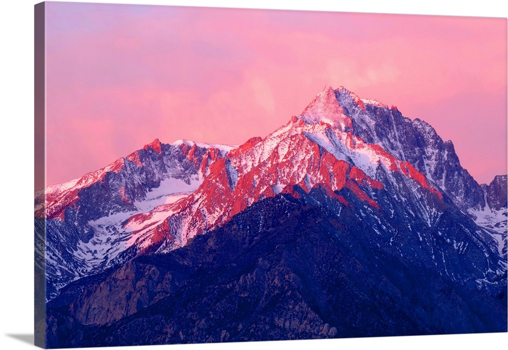 Photograph of Mount Williamson at sunrise with the pink sky reflecting onto the snowy peaks.