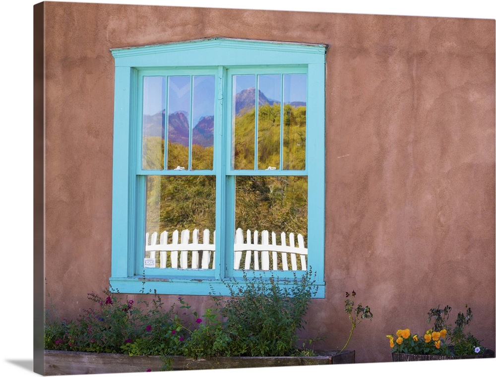 Photograph of a colorful window pane in an adobe wall.