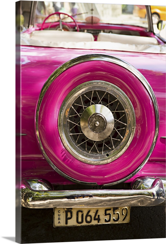 Photograph of the spare tire case on the back of a vintage hot pink car in Cuba.