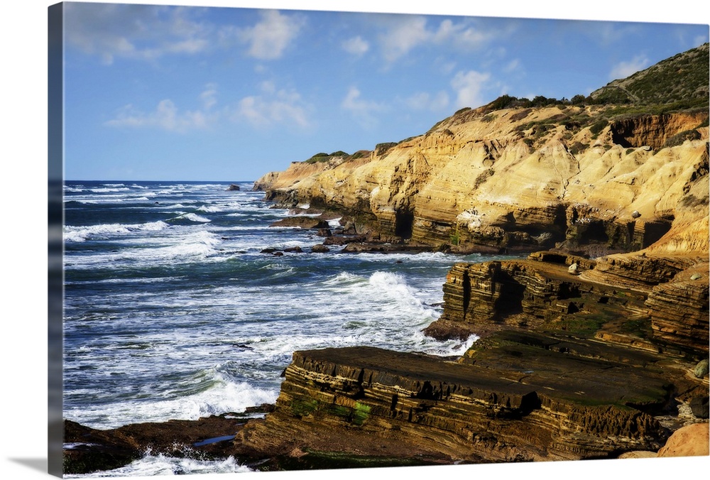 Landscape photograph of waves crashing on rocky cliffs at Point Loma, CA.