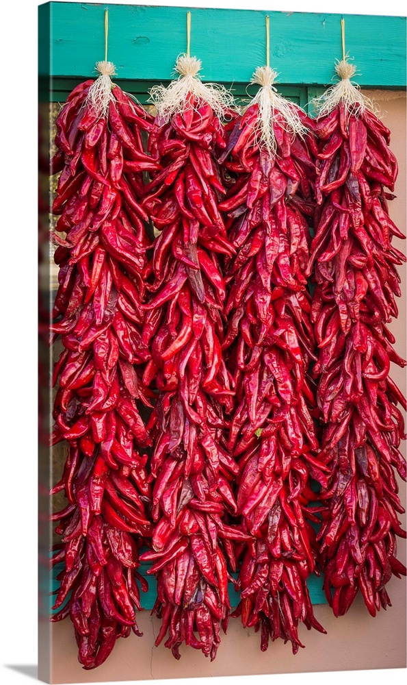 Photograph of four strings of dried chilies.