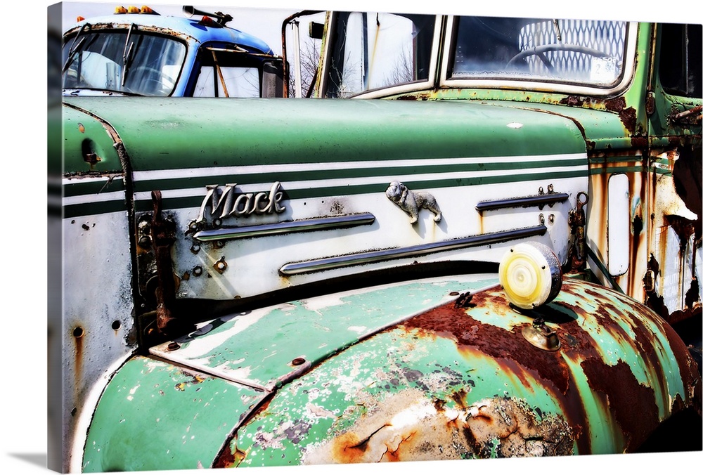 Photograph of the side of an old, rusted, green and white Mack truck.