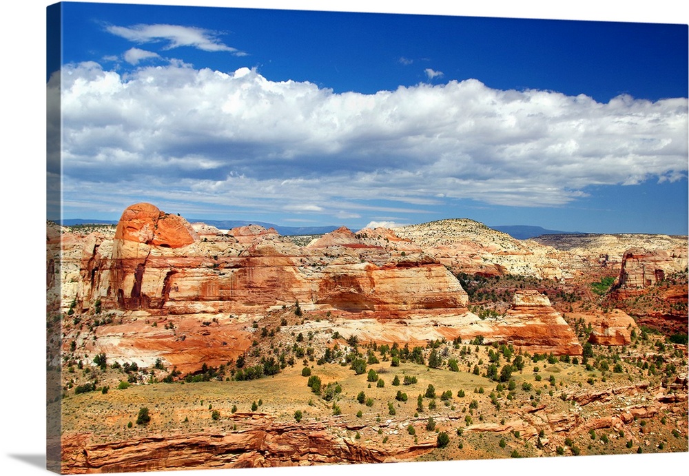 Landscape photograph of sandstone rock formations with white clouds in the sky.
