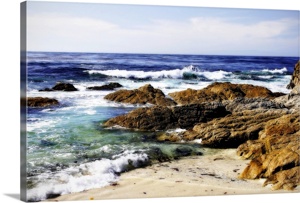 Photograph of rocky shoreline with waves crashing in.