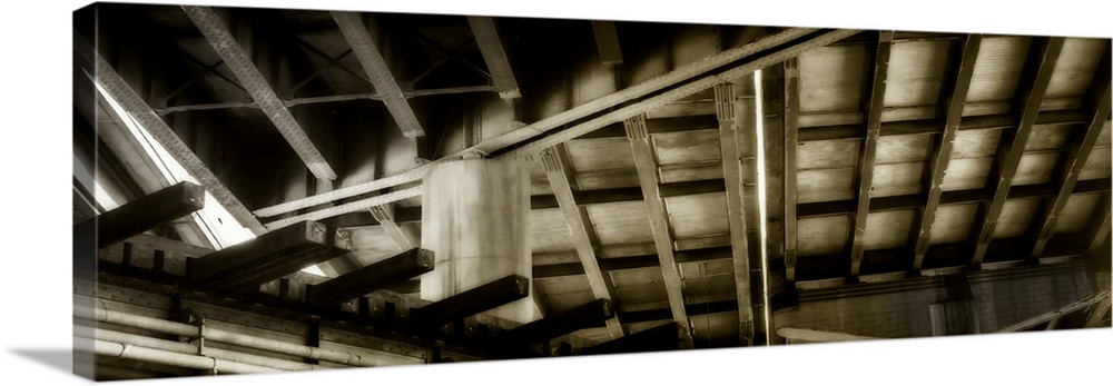 Abstract sepia toned panoramic photograph of ceiling rafters creating intriguing angles.