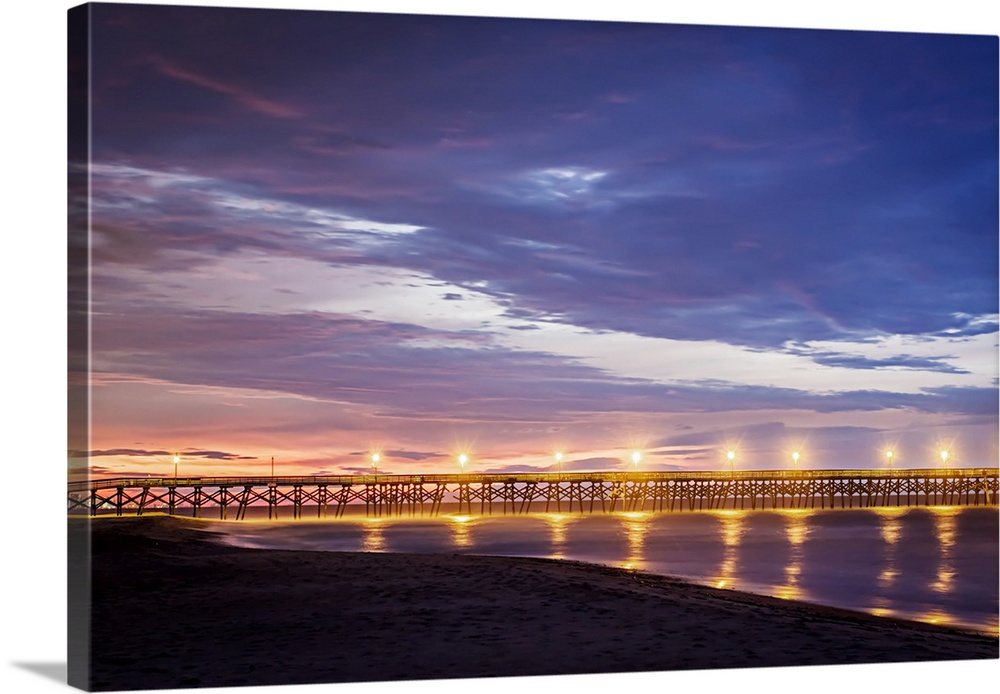 Photograph of Surfside Pier lit up at sunrise, South Carolina.