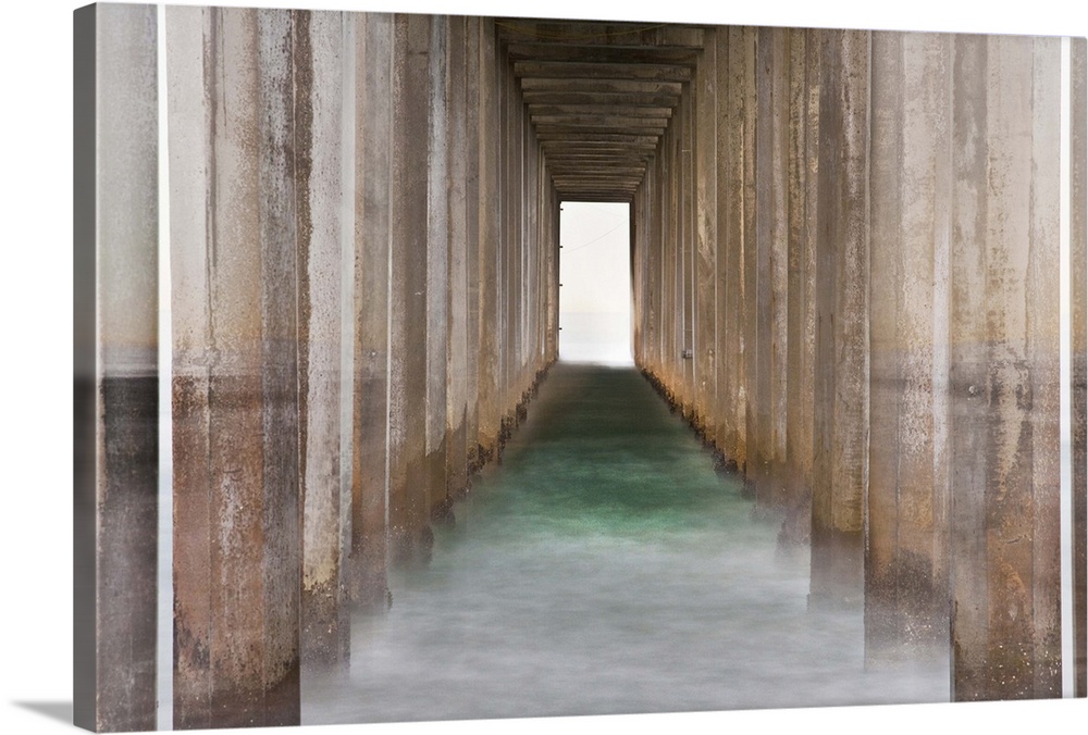Photograph of the bottom of a pier creating leading lines through the ocean to the end of the pier.