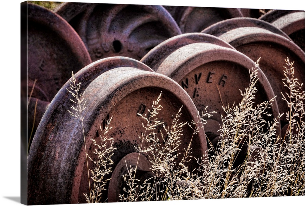 Photograph of old train wheels in the grass.