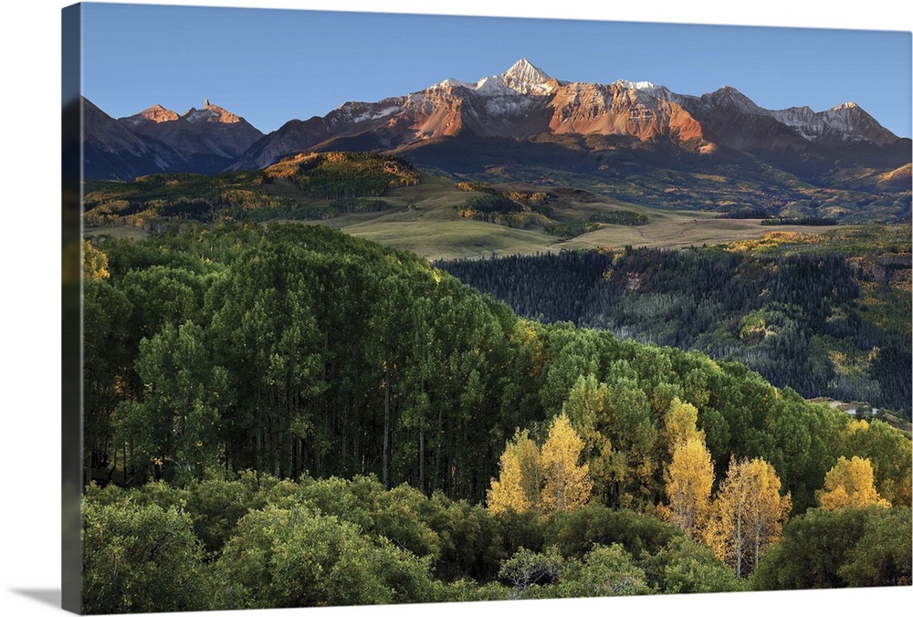 Wilson Peak in the Colorado Rockies near Telluride with a stand of yellow aspens and rolling hills in the distance just af...