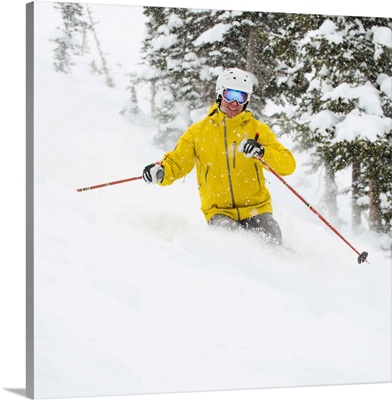 A downhill skier in yellow jacket