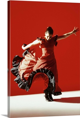 A female flamenco dancer performing a traditional Spanish dance