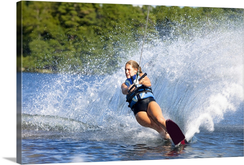 A female water skier rips a turn causing a huge water spray while skiing on Cobbosseecontee Lake near Monmouth, Maine.