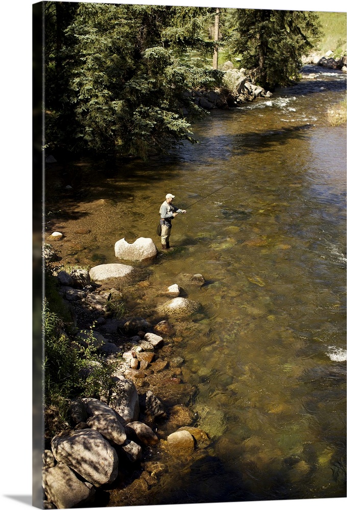 A fisherman adjusts his fly rod before fishing.
