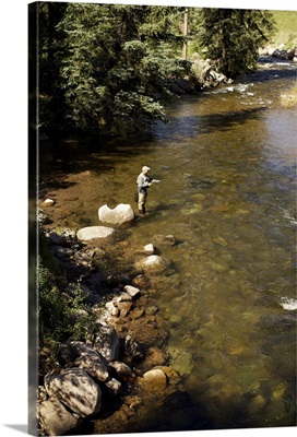 A fisherman adjusts his fly rod before fishing