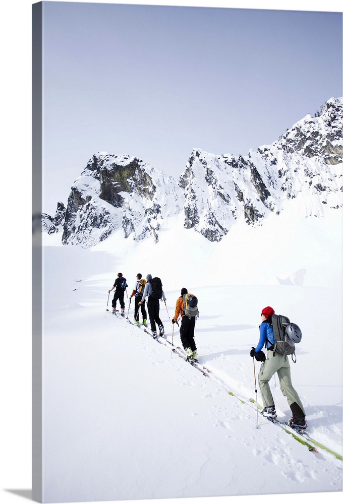 A group of skiers in the backcountry on a clear day.