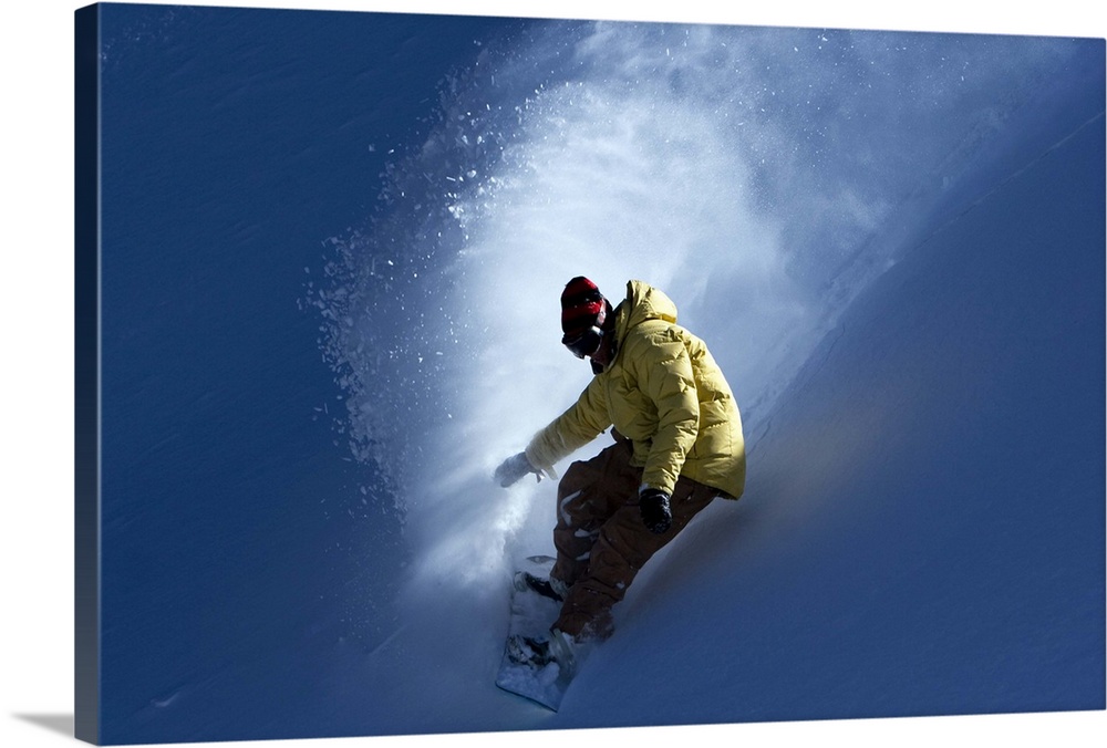 A male snowboarder catches last light on a powder day in Colorado.