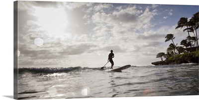 A man paddle boards in the ocean