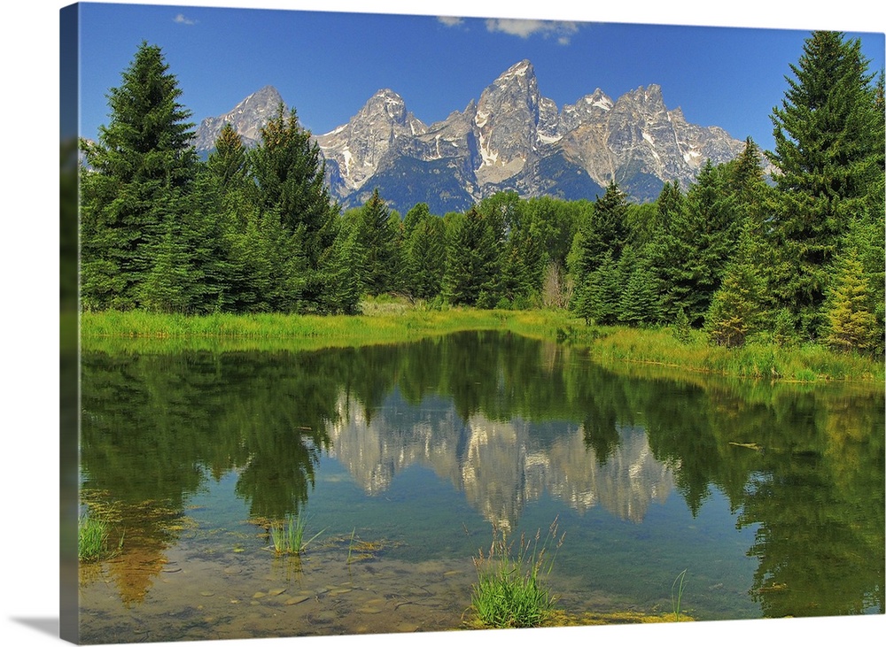 Grand Teton mountains reflected on a still pond in Grand Teton National Park
