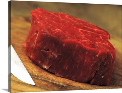 a piece of red meat with a knife