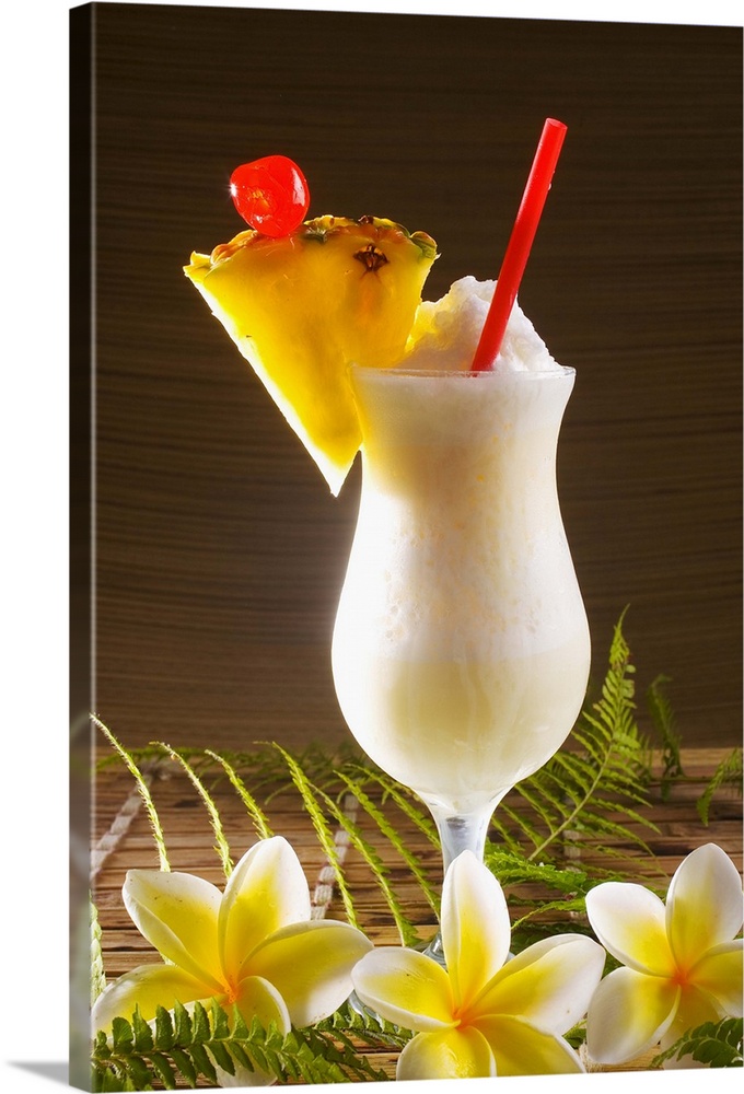 A pina colada garnished with fruit and flowers.