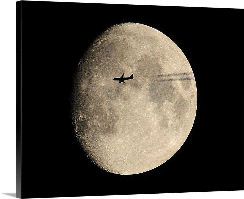 plane crossing in front of moon.