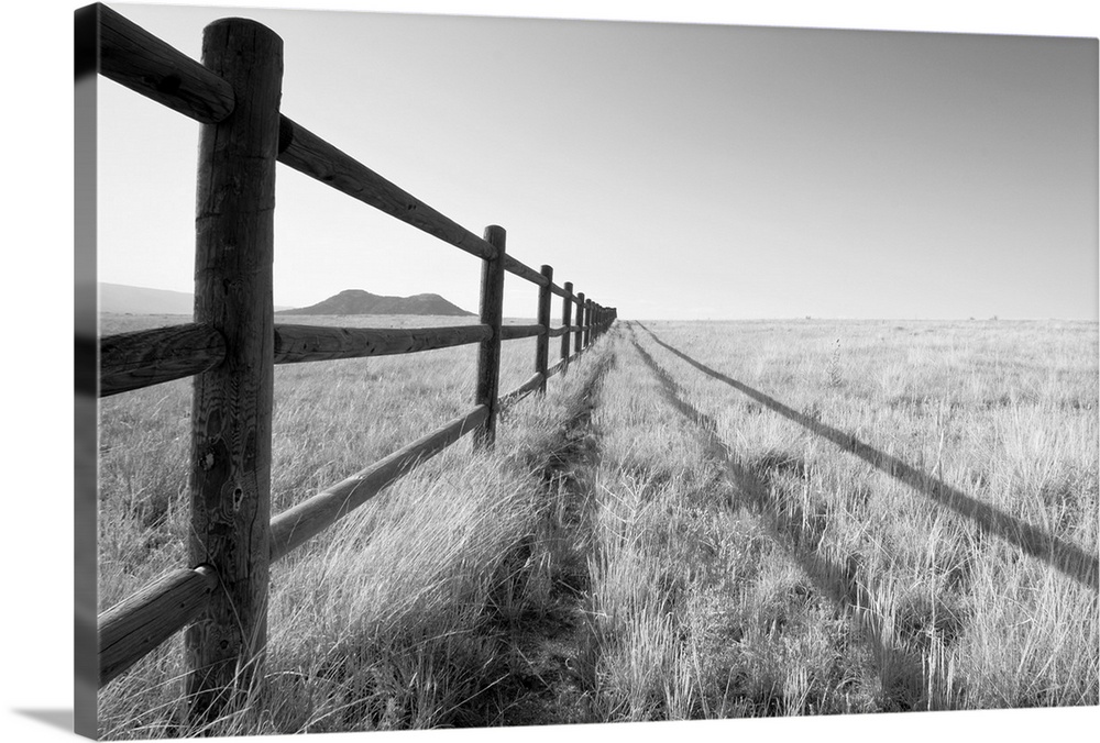 A split rail fence vanishing into the horizon and framing a mountain in the foreground. Aspen, Colorado