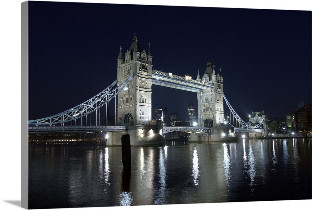 A view across the River Thames to Tower Bridge illumunated at night.