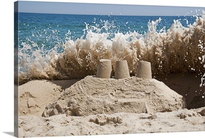 A Wave Crashes Over a Sandcastle