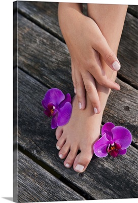A womans foot with purple orchid flowers