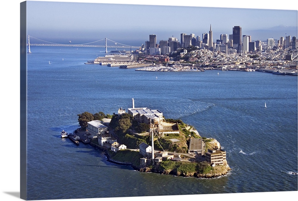 Photograph taken from high above Alcatraz on a sunny day with the city skyline and bridge in the background.
